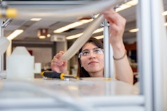 A U of G student holds up lab equipment during an experiment