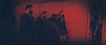 Students in a line beside a brick wall