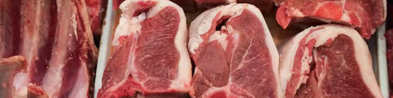 Raw cuts of beef meat hanging side by side