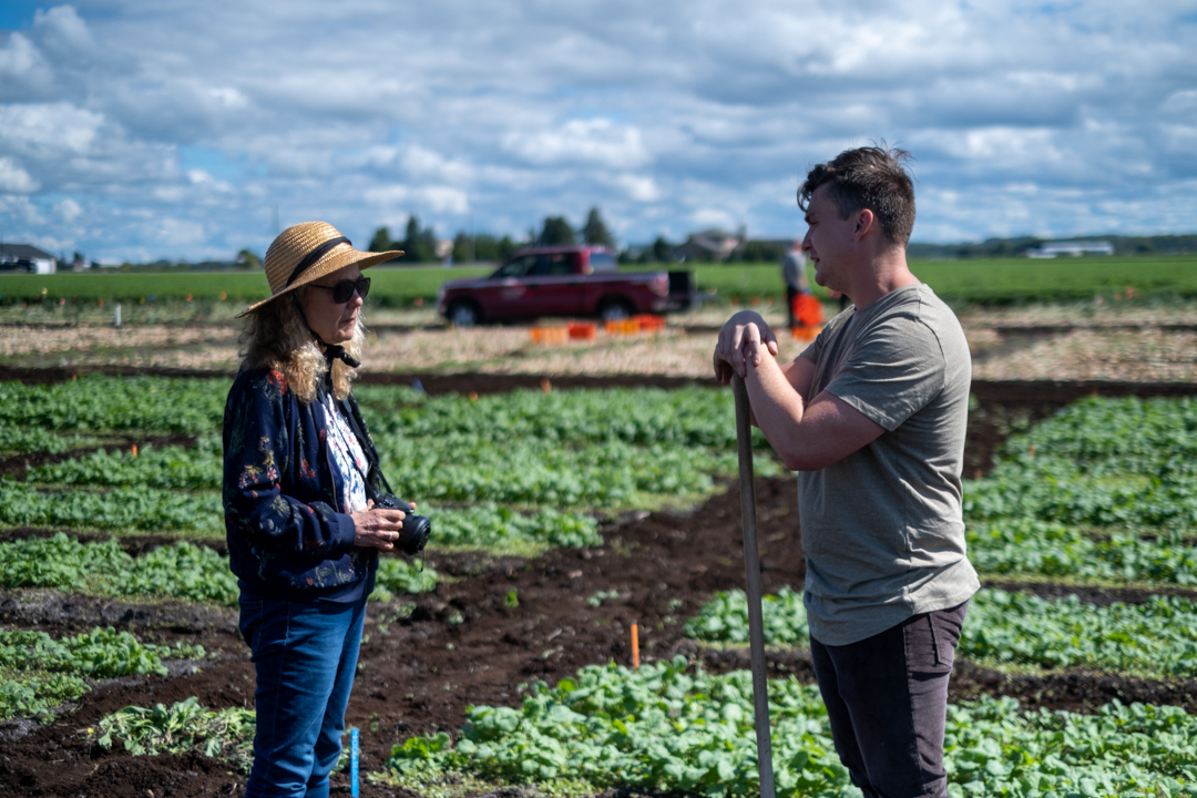 Dr. Mary Ruth McDonald standing in the field at the Ontario Crops Research Centre, Bradford with a staff member.