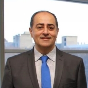 Dr. Shayan Sharif smiling in a suit and tie