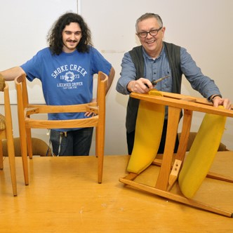 Furniture swap volunteers pose with chairs in the program