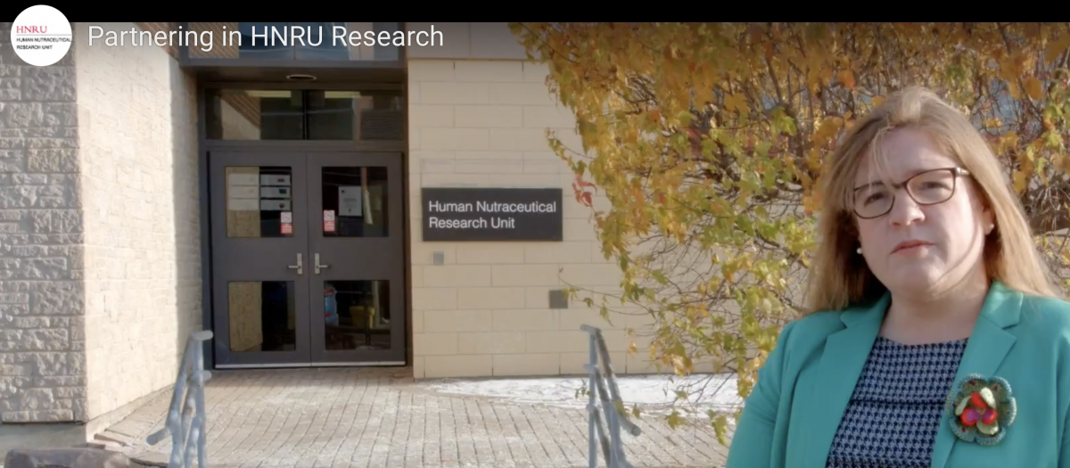 A photo of Dr. Amanda Wright, standing in front of the HNRU.