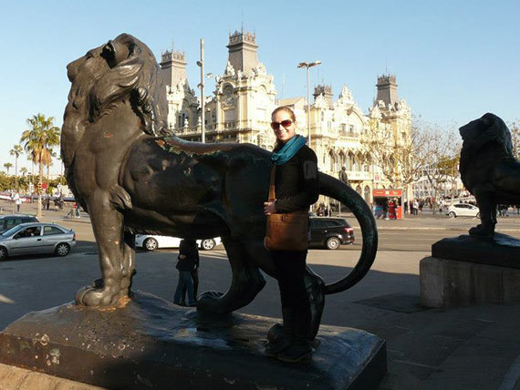 Emily poses with lion statue in Barcelona