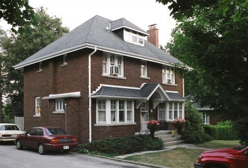 11 University Avenue East is a 1926 brown-brick house with white trim and four steps up to the front door