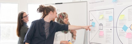 three people looking at business strategy board