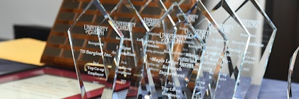 A table with a set of glass awards given by the University of Guelph and addressed to various top co-op employers