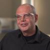 Prof. Keith Warriner in metal rimmed glasses and black dress shirt.