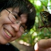 Close up of Andrew smiling and holding a large insect