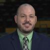 Mike in green dress shirt, plaid tie and dark suit jacket.