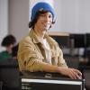 Computer Science student, Jesse Varkul, leans on a computer monitor.