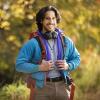 Jordan Thakar stands in The Arboretum wearing a blue jacket and holding the straps of his backpack