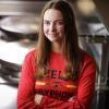 Sarah Ribey stands with her arms crossed in front of an industrial kitchen space at the University of Guelph