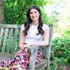 Marah LaForge sitting on a wooden bench and smiling for the camera
