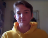 Toby wears a yellow hoodie and looks at the camera.
