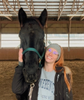 Woman posing with horse and smiling
