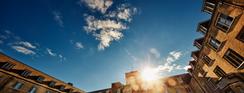 A picture of Johnston Hall, blue skies with the sun rising over the building.