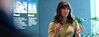 mikayla in a boardroom giving a speech