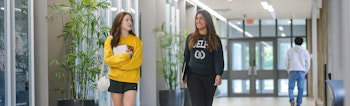 Two students walk together while chatting and laughing in the engineering building.