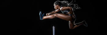 woman jumps over hurdle