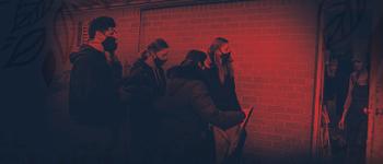 Students in a line beside a brick wall