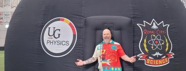 man standing with arms out to his side in front of an inflatable dome