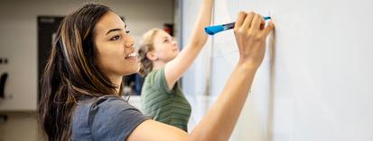 Female student using a whiteboard