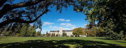 Johnston Hall in the distance, framed by trees in the foreground