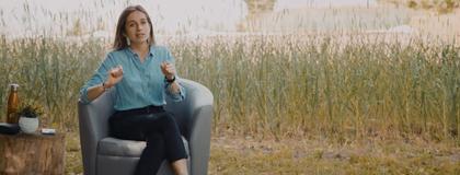 Margarita sitting in chair with tall grass behind her