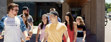 A group of students walking toward the camera in front of the Engineering building.