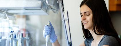 person working in lab, holding syringe