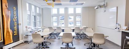 An image of a classroom with tables and chairs