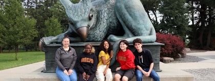 students with gryphon statue