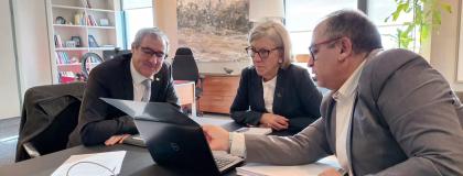 three executives looking at a laptop together