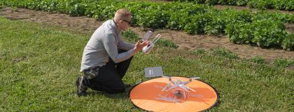 Student in a field about to fly a drone
