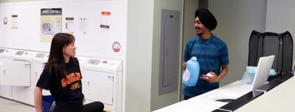 Two students doing laundry in East Residence