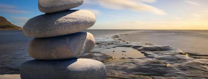 A serene beach scene featuring a carefully balanced stack of rocks resting on the sandy shore.