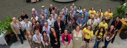 Arial view of a group of alumni standing together looking up.