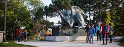 Students gather around the Gryphon statue on the U of G campus.