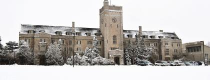 Photo of the Johnston Hall building on the U of G campus in the winter, with snow on the ground and trees