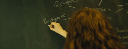 Student Writing on a Chalk Board