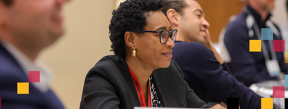 A person sitting at a table looking at the front of the room.