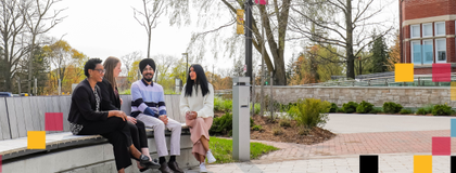 Four people sitting on a bench talking in Lang Plaza.