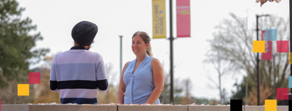 Two people talking in Lang plaza.