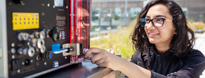 Female student adjusting a knob on a wind-reading device