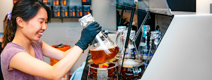 Woman in lab holding beaker of fluid