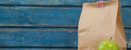 Brown lunch bag with an apple.