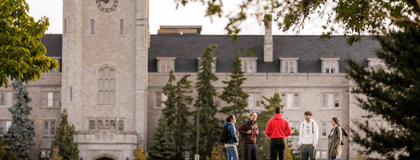 U of G's campus shot featuring Johnston Hall and some students besides the trees.