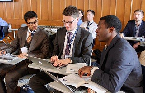 students working together in a classroom wearing suits