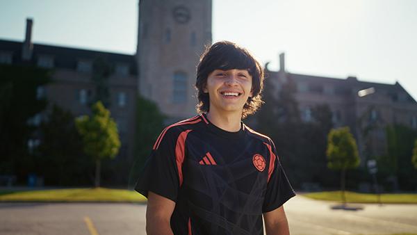 Smiling male student in front of Johnston Hall.